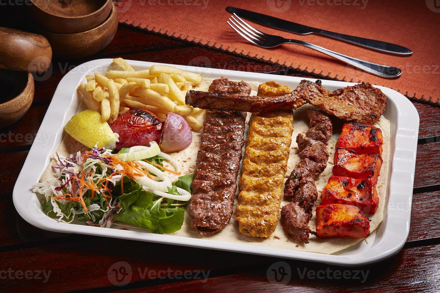 speziato bbq misto griglie piatto con tikka boti kabab, patatine fritte, insalata servito nel piatto isolato su tavolo lato Visualizza di mezzo est cibo foto