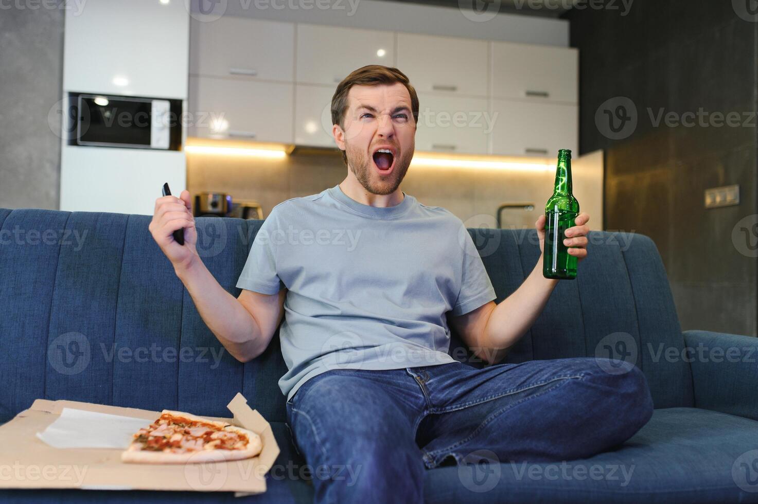 Guardando il calcio gioco mangiare pizza, bere birra. foto