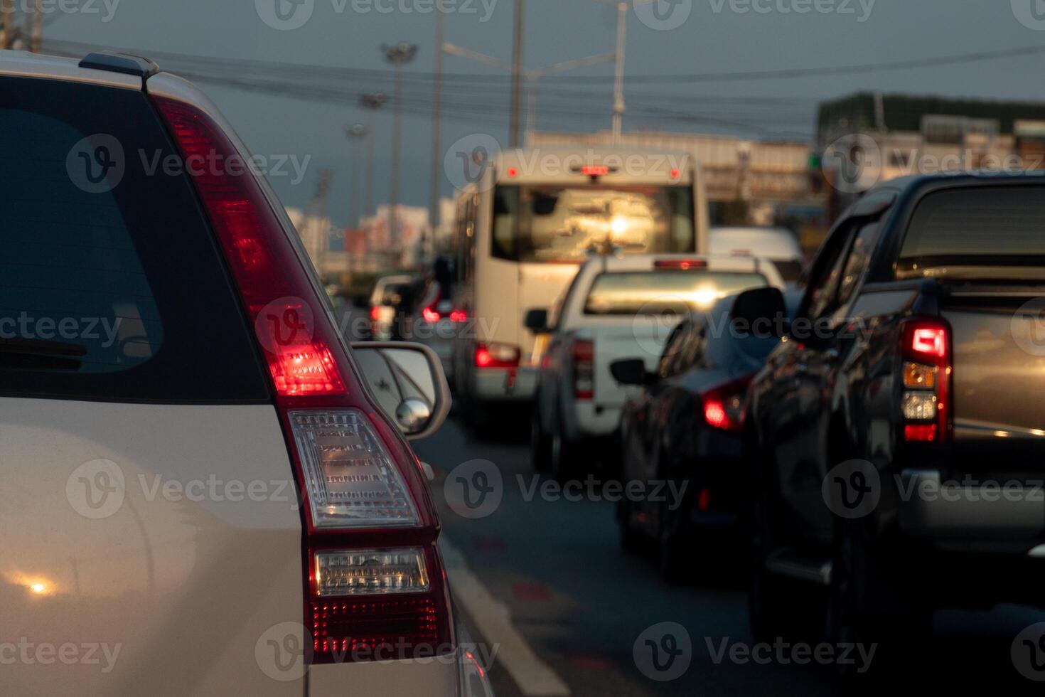 posteriore lato di bianca auto con girare su freno luce. traffico marmellata su il asfalto strada nel il città. macchine traffico marmellata nel il sera. foto