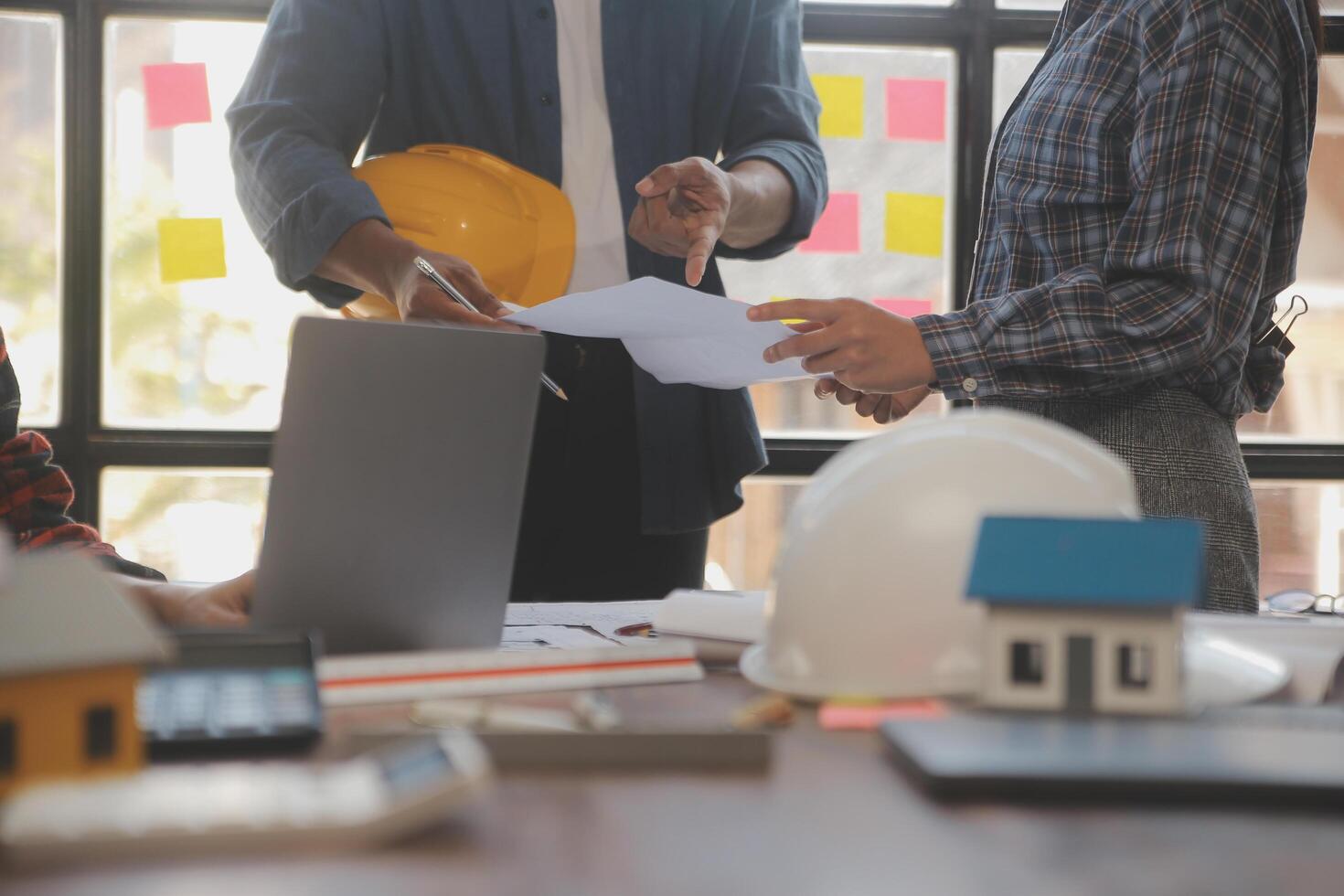 un' squadra di costruzione ingegneri parla per manager e costruzione lavoratori a il costruzione luogo. qualità ispezione, opera Piano, casa e industriale edificio design progetto foto