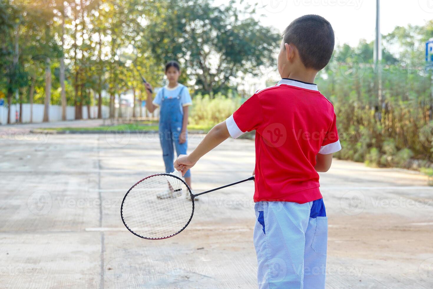asiatico ragazza e ragazzo giocare badminton all'aperto a il parco insieme su vacanza. morbido e selettivo messa a fuoco. foto