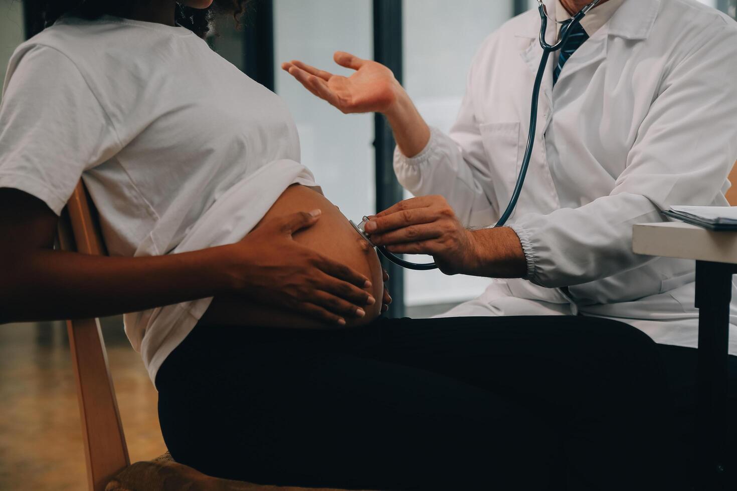 femmina medico è controllo incinta donna con stetoscopio. concetto cura per incinta donna foto