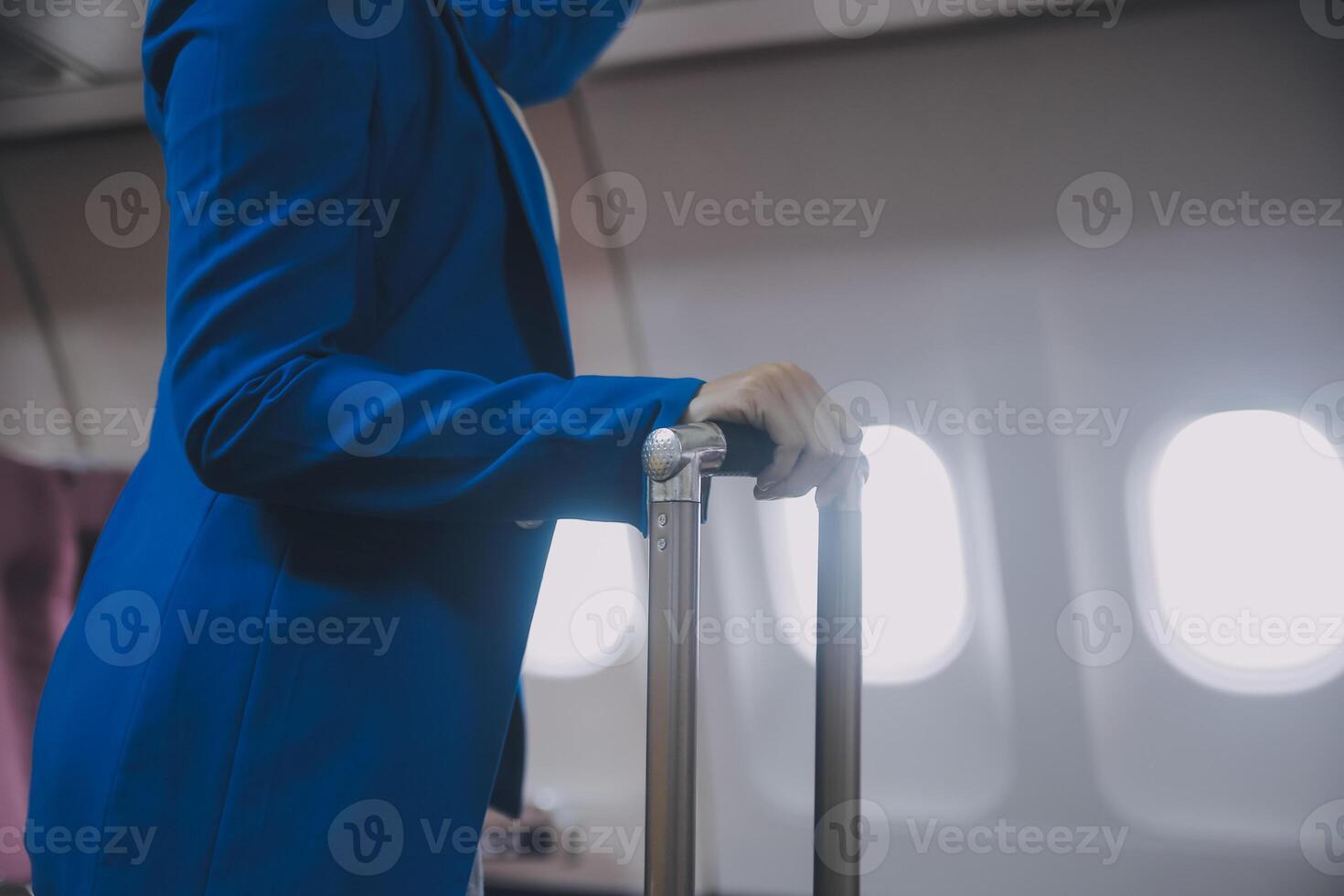 asiatico femmina viaggiatore mettendo bagaglio in alto armadietto su aereo durante imbarco. foto