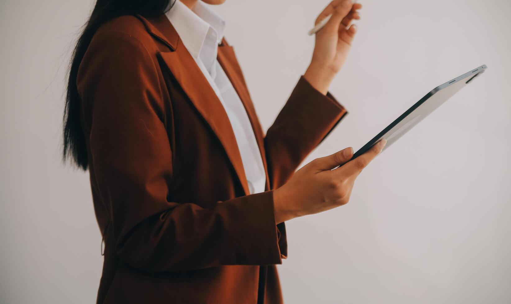 il ritratto di una giovane donna asiatica libera professionista sta lavorando sul tablet del computer in un ufficio moderno. fare un rapporto di analisi contabile dati di investimento immobiliare, concetto di sistemi finanziari e fiscali. foto