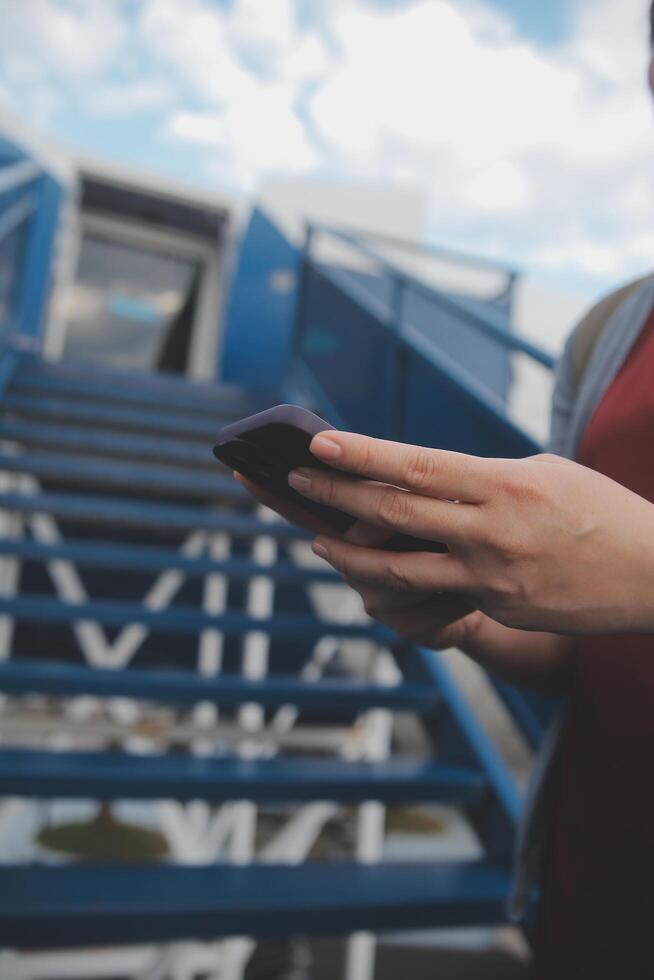 bionda femmina turista controllo arrivo notifica su smartphone seduta su posto a sedere di aereo con netbook.young donna d'affari Condividere media a partire dal telefono su il computer portatile computer durante aereo volo foto