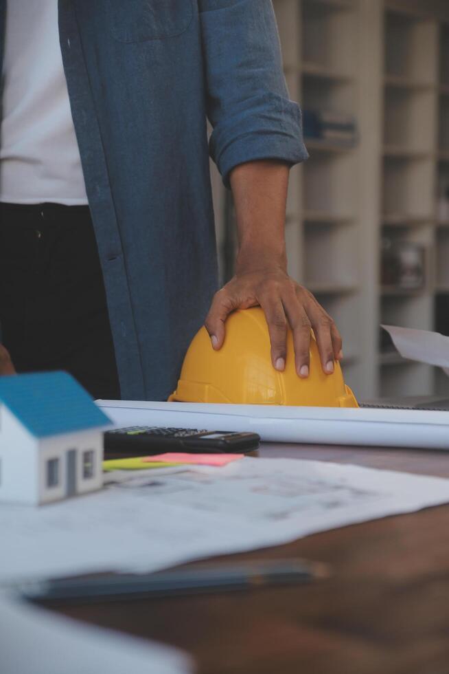 un' squadra di costruzione ingegneri parla per manager e costruzione lavoratori a il costruzione luogo. qualità ispezione, opera Piano, casa e industriale edificio design progetto foto