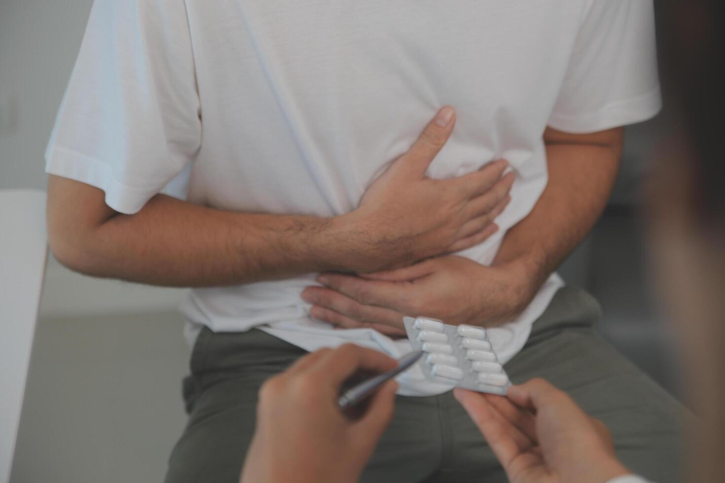 uomo sofferenza con acuto stomaco dolore seduta a casa. mano di maturo tipo Tenere addome sofferenza a partire dal dolore, diarrea o indigesto problema. caucasico tipo urgente su pancia su doloroso sensazione foto