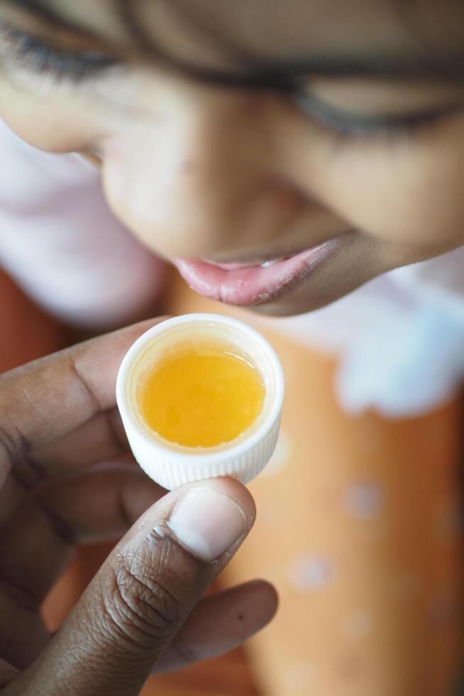 bambino assunzione un' dose di tosse sciroppo. foto