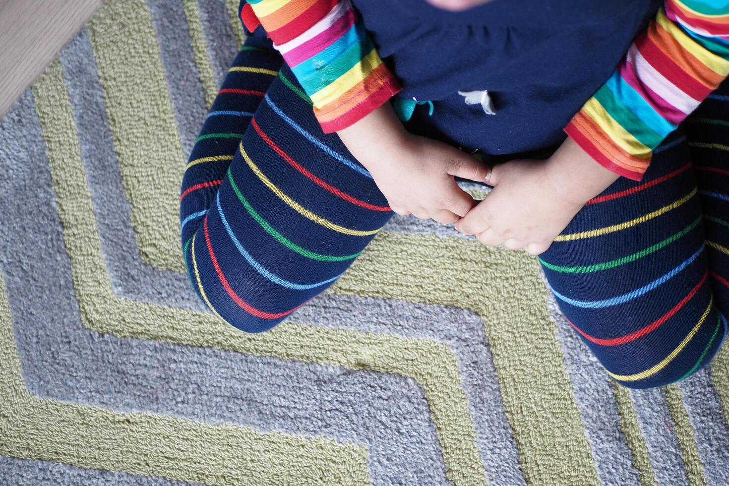 bambino seduta w posizione su il pavimento . foto