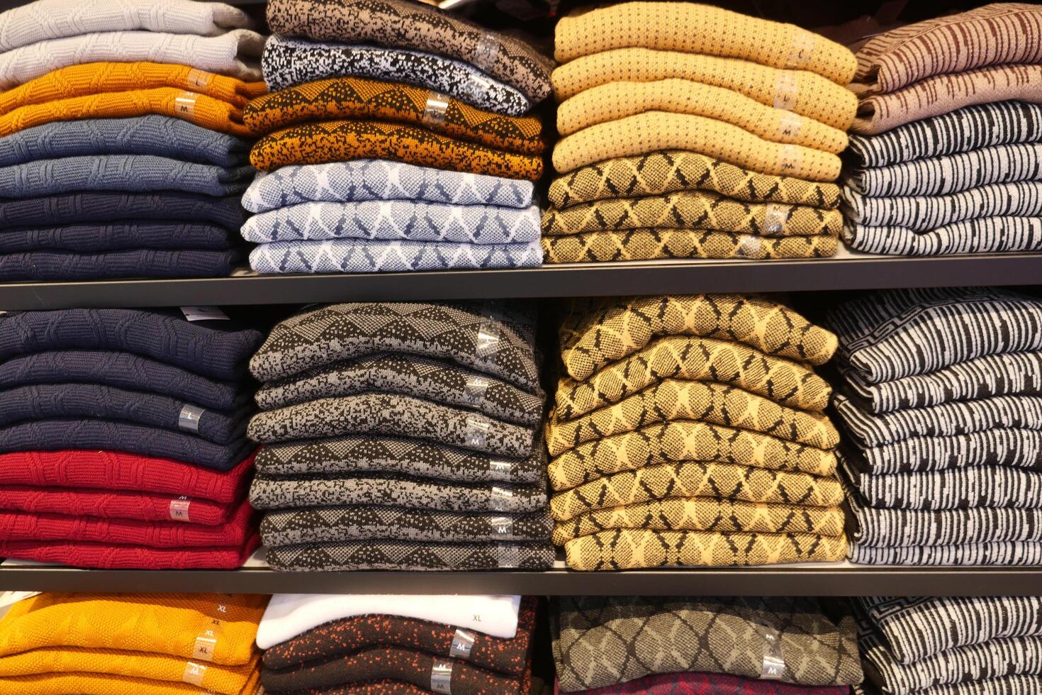 colorato camicie su mensola nel un' Al dettaglio negozio foto