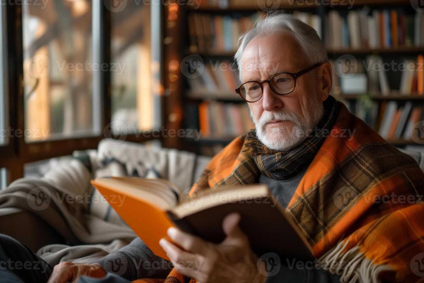 ai generato un vecchio uomo si siede su il divano e è assorbito nel lettura un' prenotare, il suo Attenzione focalizzata su il pagine. lui sembra rilassato e contento con il suo lettura attività foto