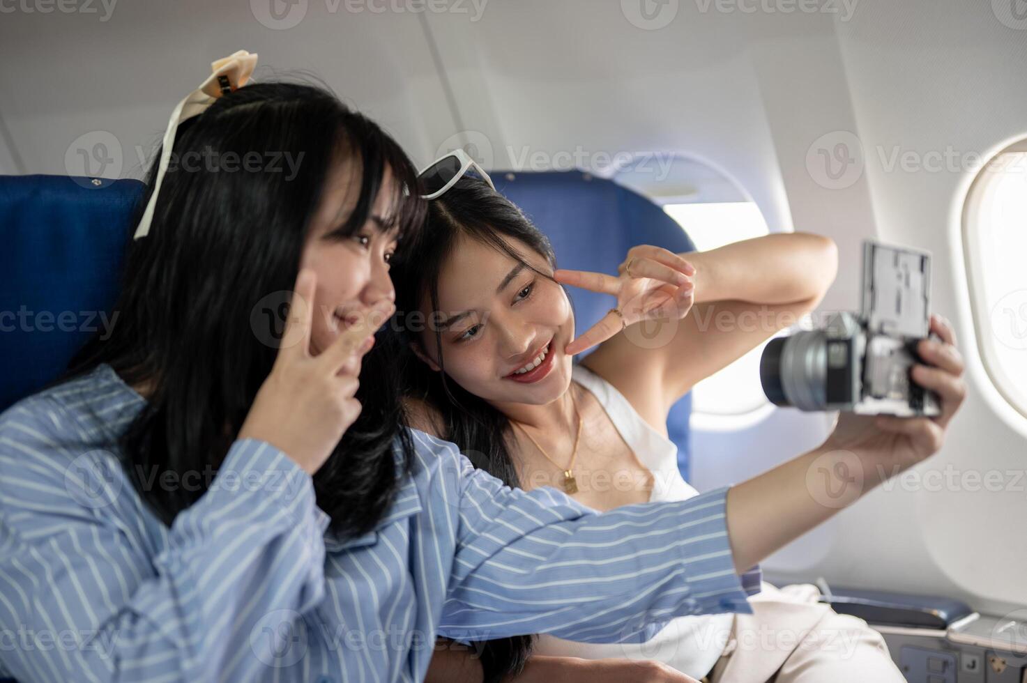 Due contento asiatico femmina viaggiatori siamo assunzione un' autoscatto insieme durante il volo. foto