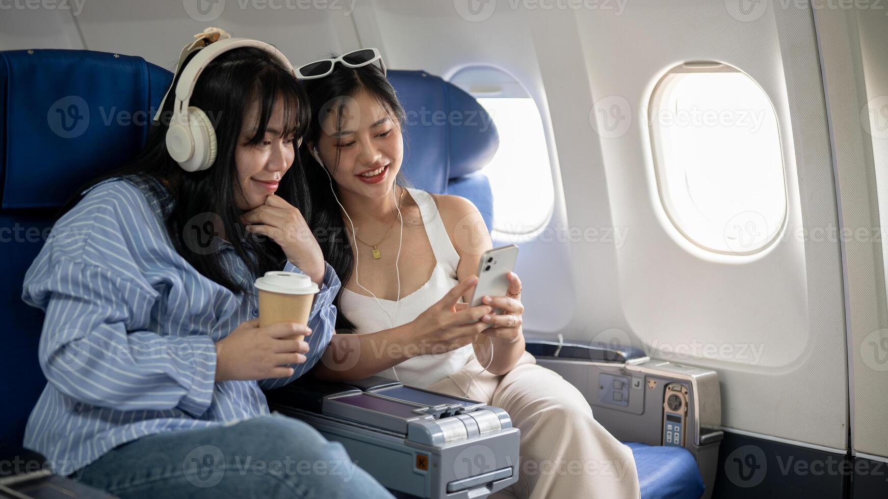Due contento asiatico femmina amici siamo godendo parlando durante il volo per loro vacanza insieme foto
