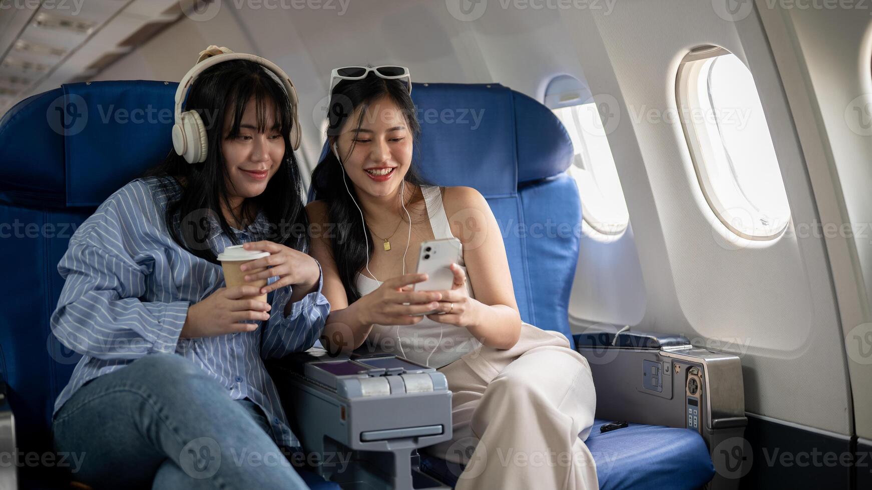 Due contento asiatico femmina amici siamo godendo parlando durante il volo per loro vacanza insieme foto