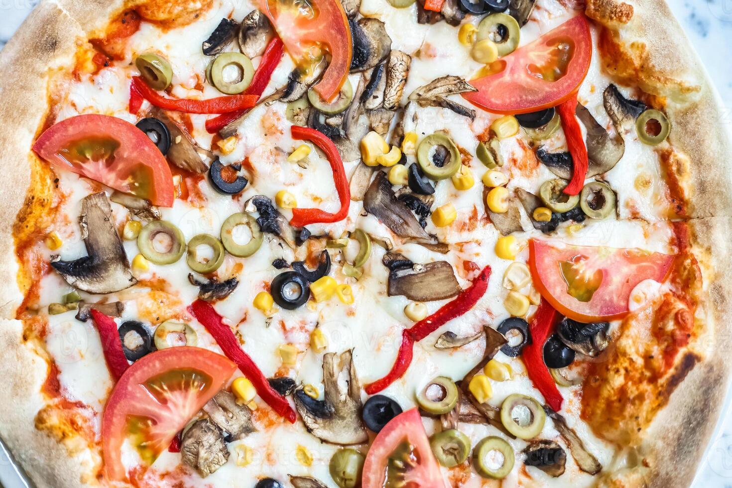 delizioso Pizza sormontato con pomodori, olive, peperoni, e funghi foto