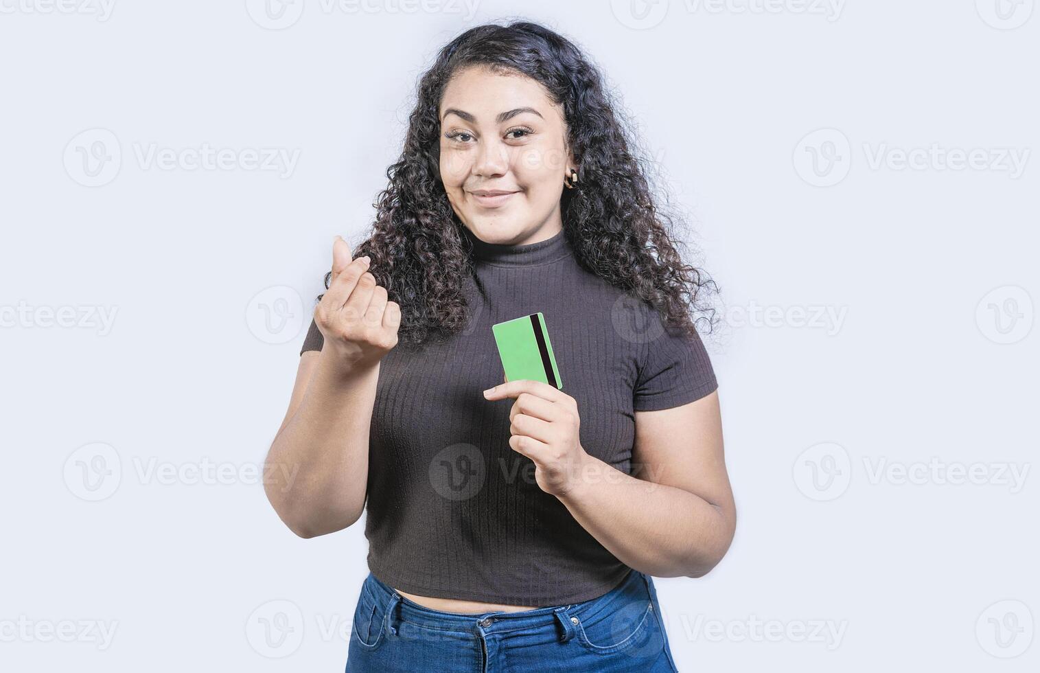 attraente ragazza Tenere credito carta fabbricazione i soldi gesto con dita isolato, guardare a telecamera foto