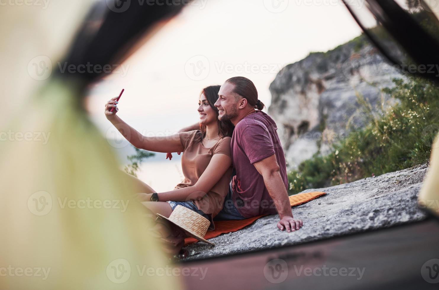 due persone sedute sulla roccia e guardando la natura meravigliosa foto