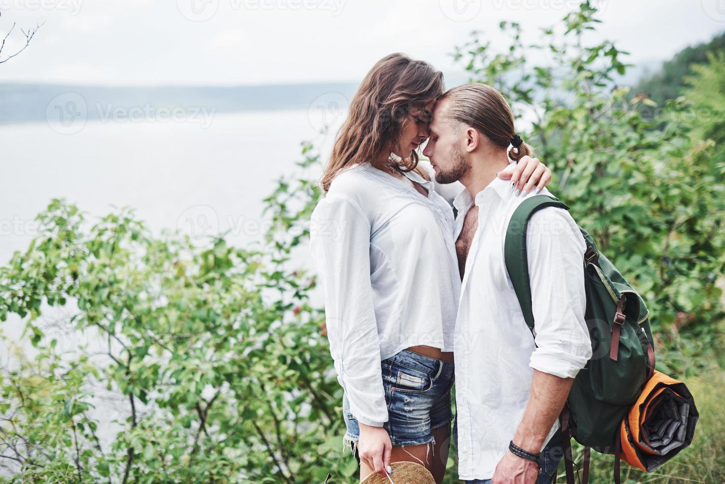 sguardo sensuale. la giovane coppia ha deciso di trascorrere le proprie vacanze in modo attivo vicino al lago sullo sfondo foto