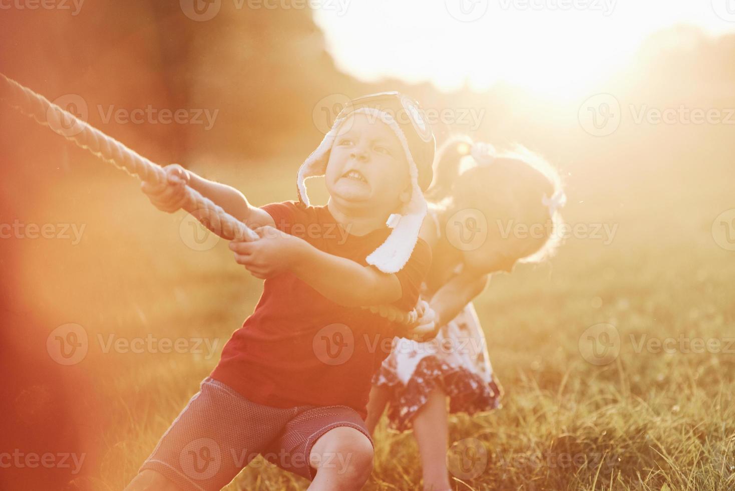 sento la forza nelle mie mani. questo è un tiro alla fune con papà sulla bellissima erba di una calda giornata di sole foto
