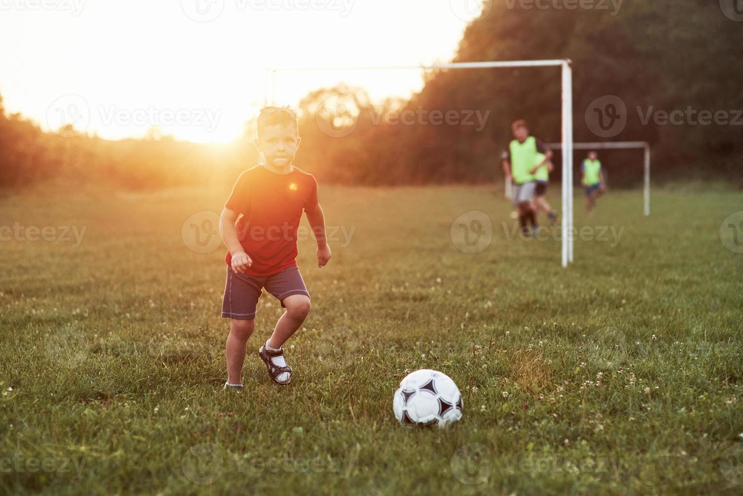 posso vedere il portiere da qui il ragazzo gioca a calcio in una calda giornata di sole e va a segnare un goal foto