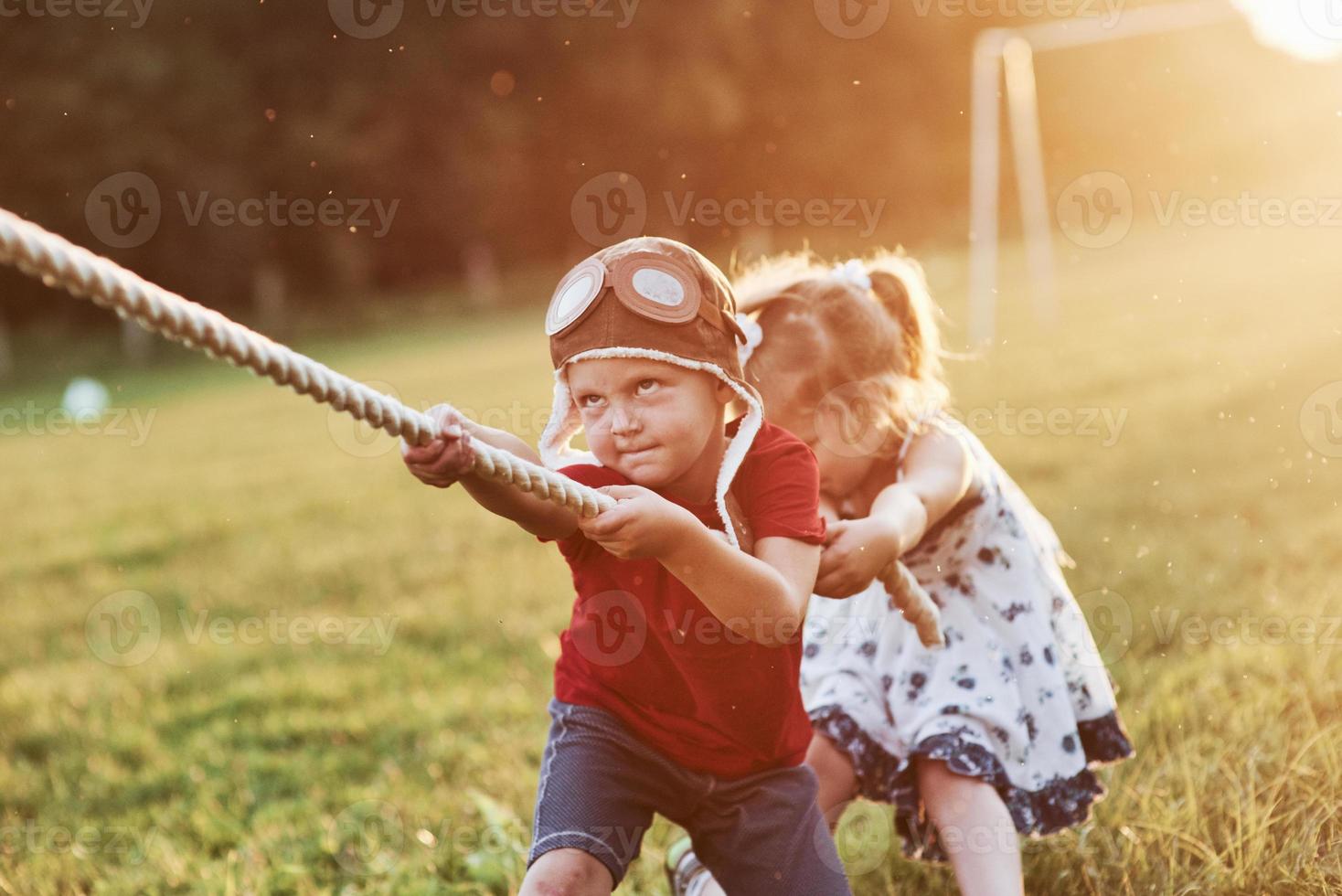 è tutta una questione di lavoro di squadra. questo è un tiro alla fune con papà sulla bellissima erba di una calda giornata di sole foto