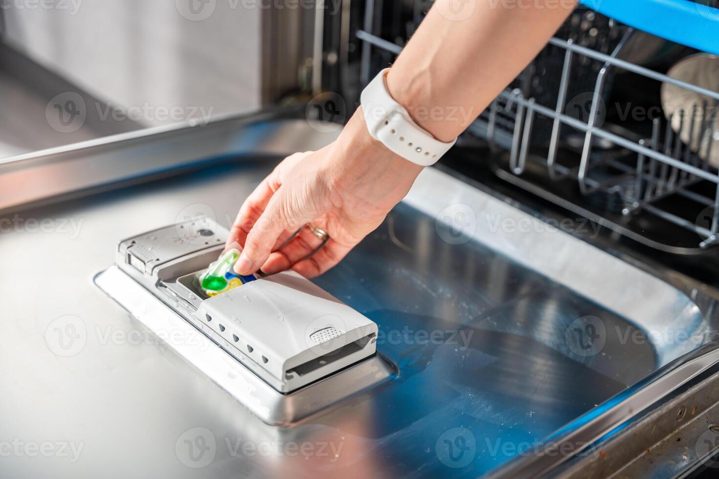 donna mano mettendo detergente, multifunzione tavoletta in lavastoviglie. domestico lavoretti, doveri con moderno cucina apparecchio. foto