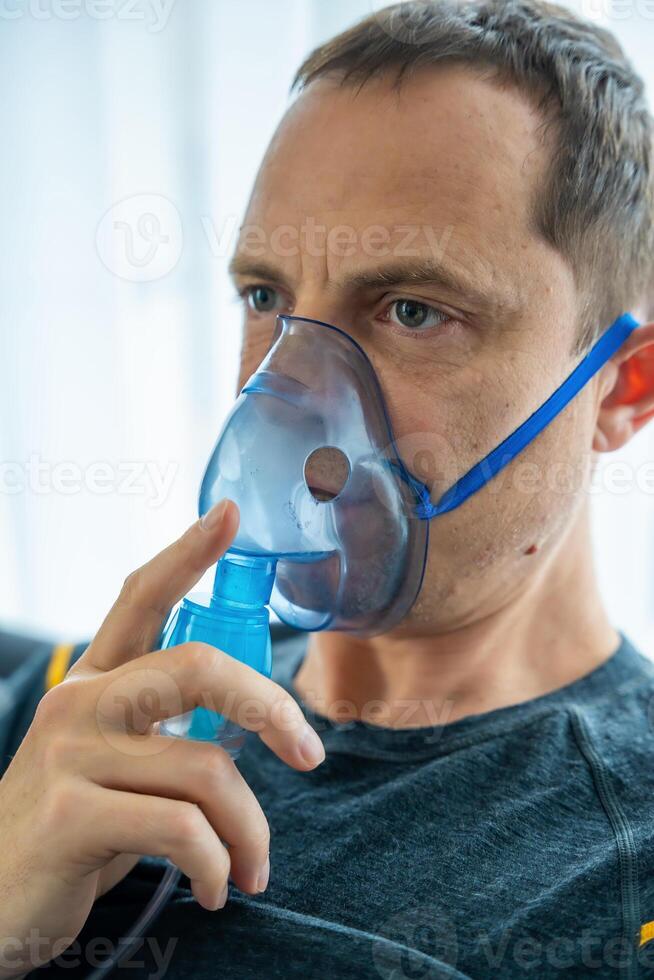 malsano uomo indossare nebulizzatore maschera nel casa. Salute, medico attrezzatura e persone concetto. alto qualità foto