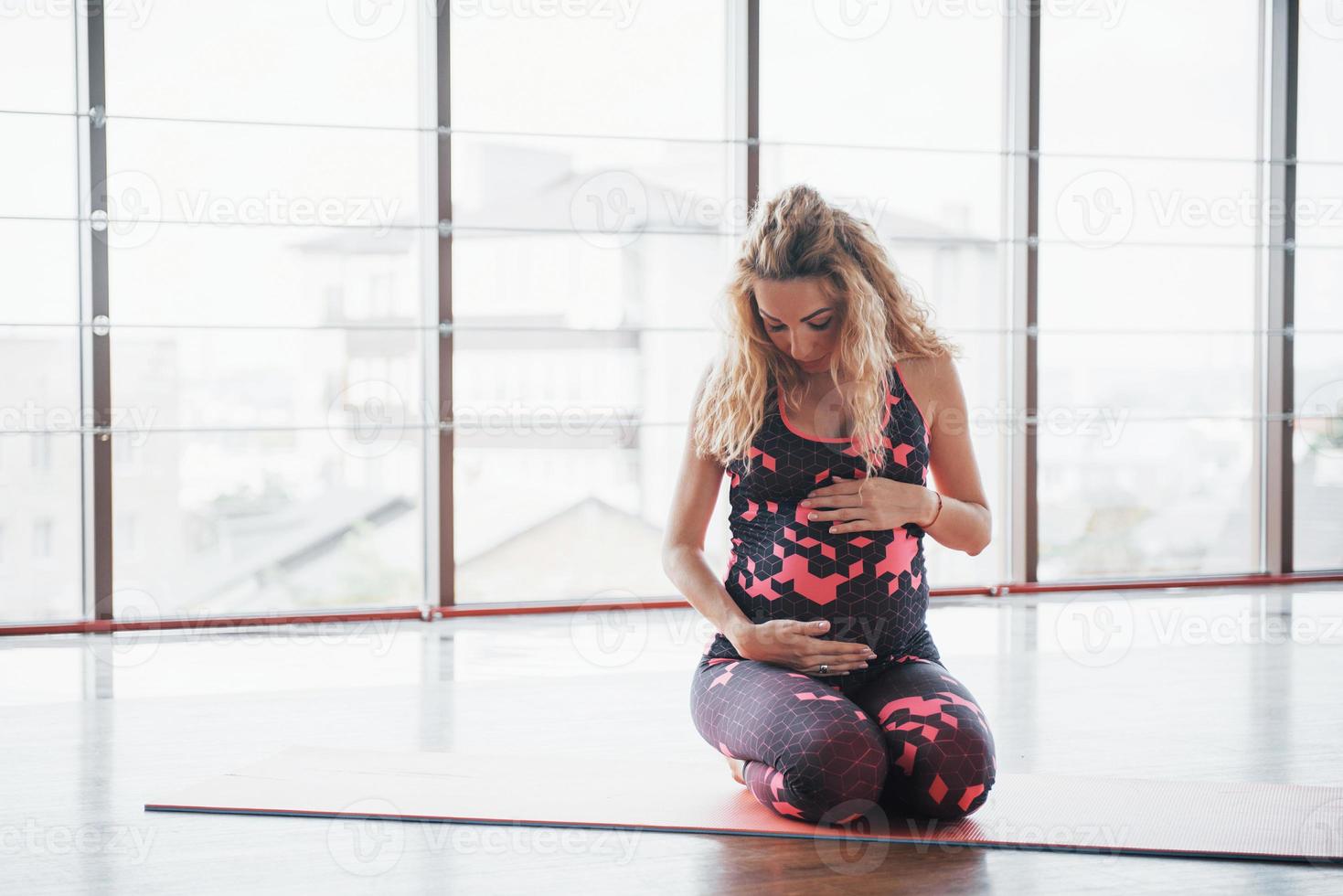 concetto di gravidanza yoga e fitness. ritratto di una giovane modella di yoga in gravidanza che si sta sviluppando al chiuso. foto