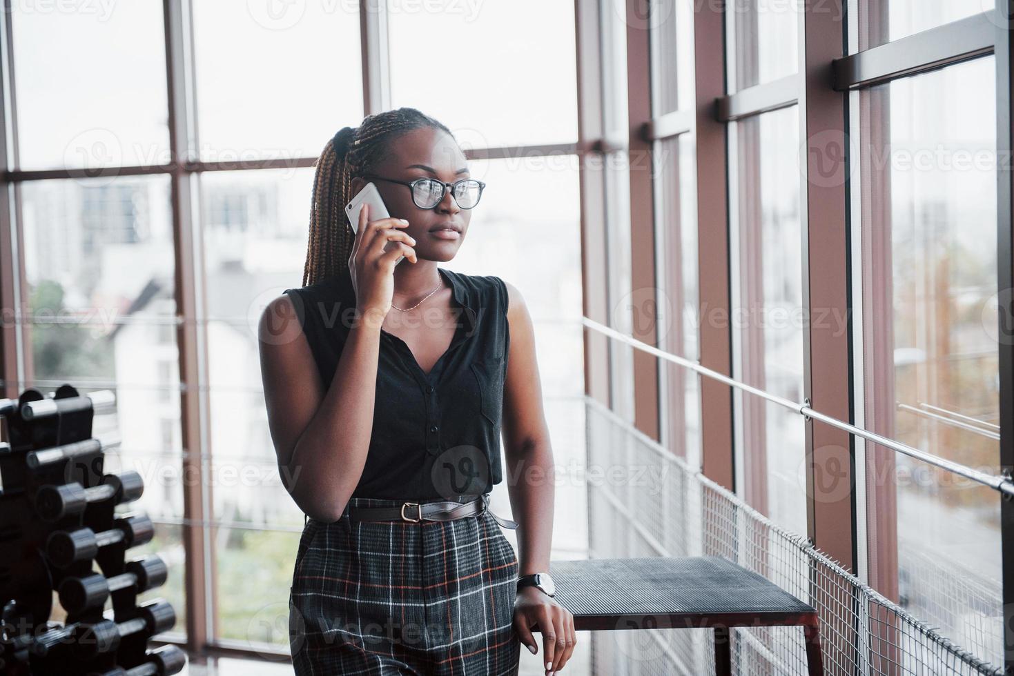 una donna d'affari americana parla al cellulare in ufficio. foto