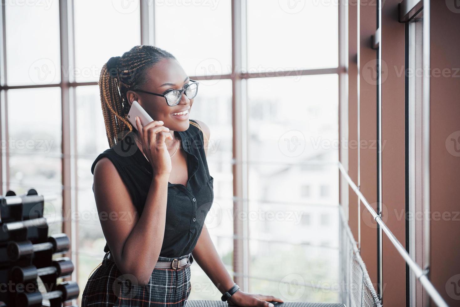 una donna d'affari americana parla al cellulare in ufficio. foto