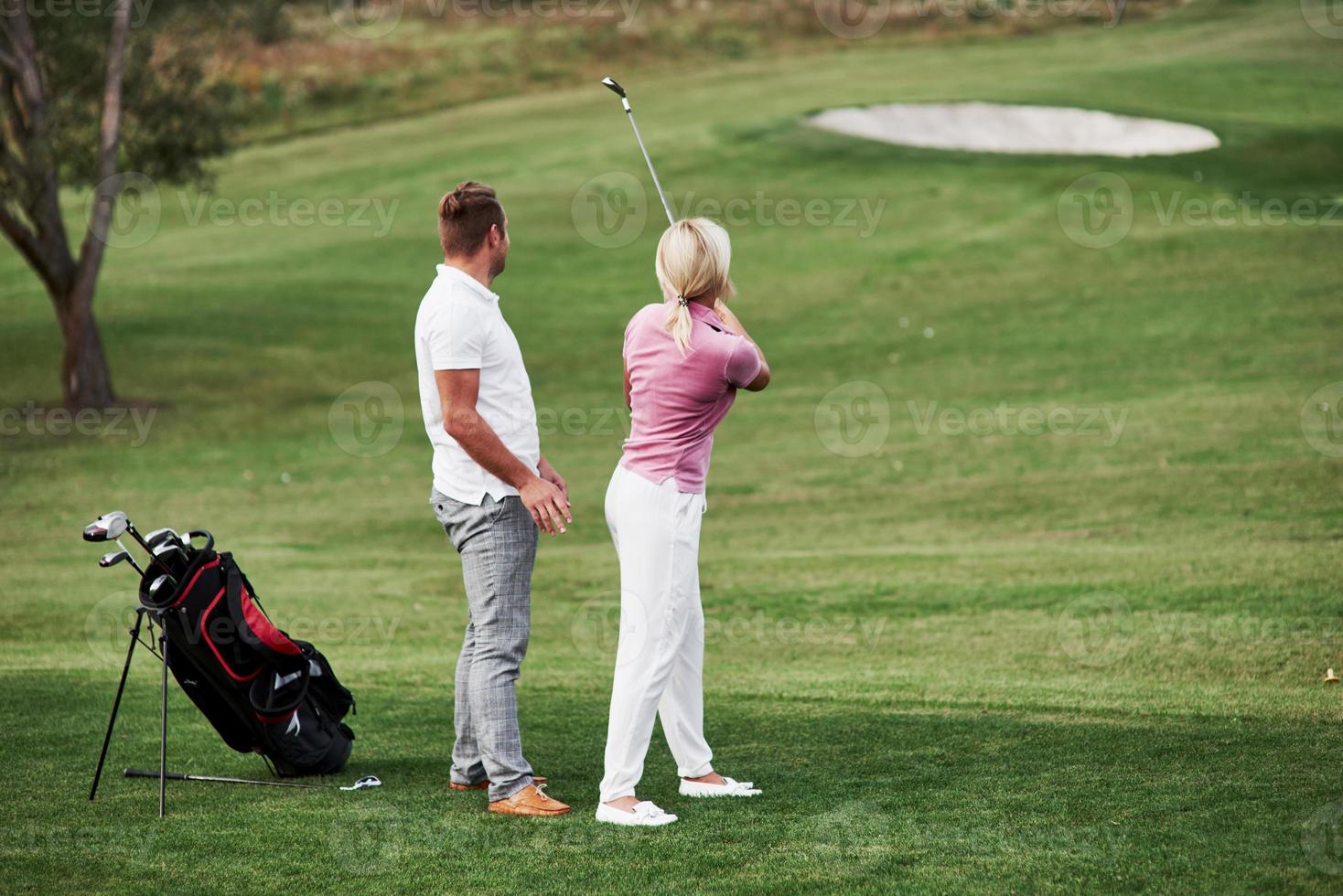 guarda quanto è lontana la pallina. un paio di giocatori di golf si divertono durante il fine settimana foto