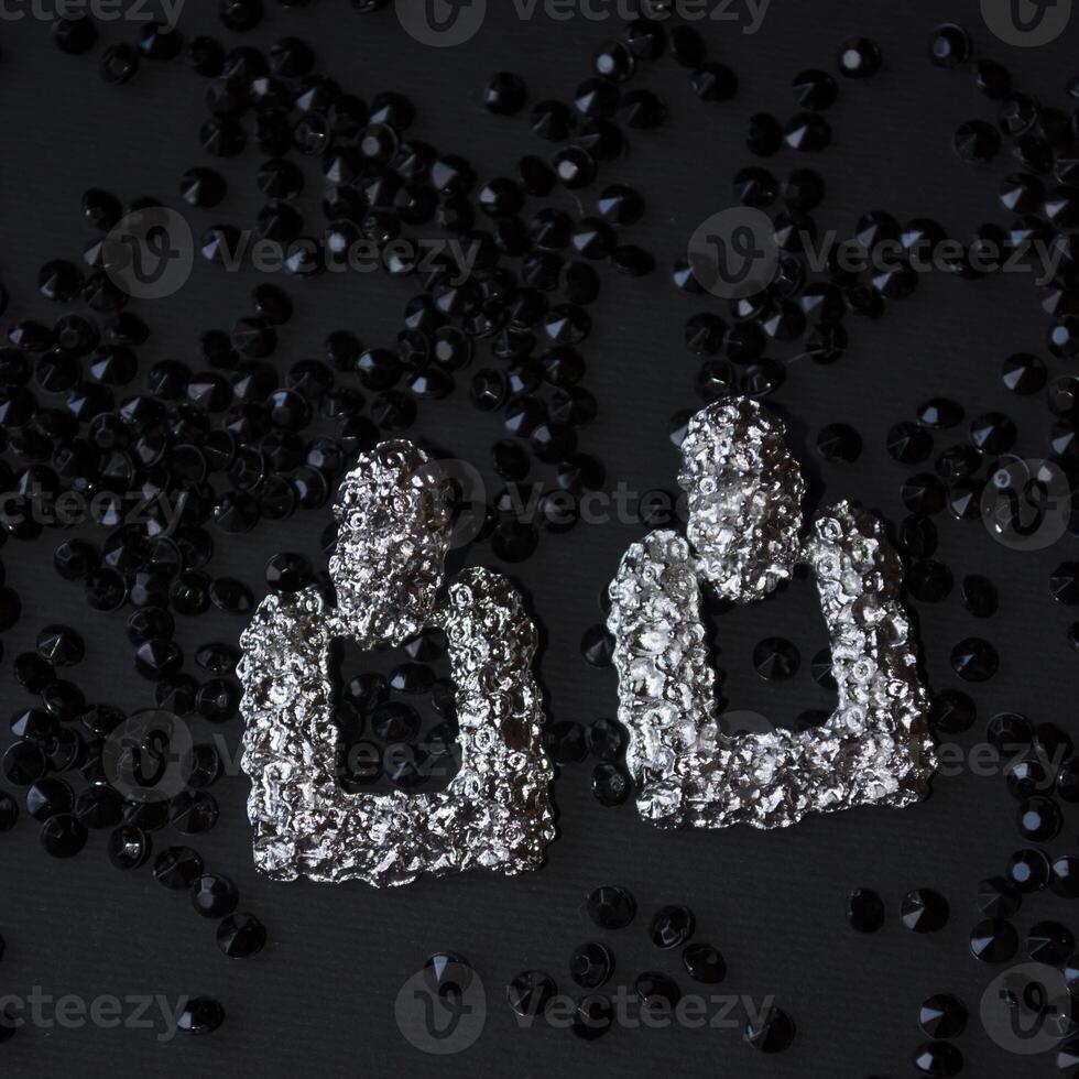 argento orecchini su un' nero sfondo con arredamento foto