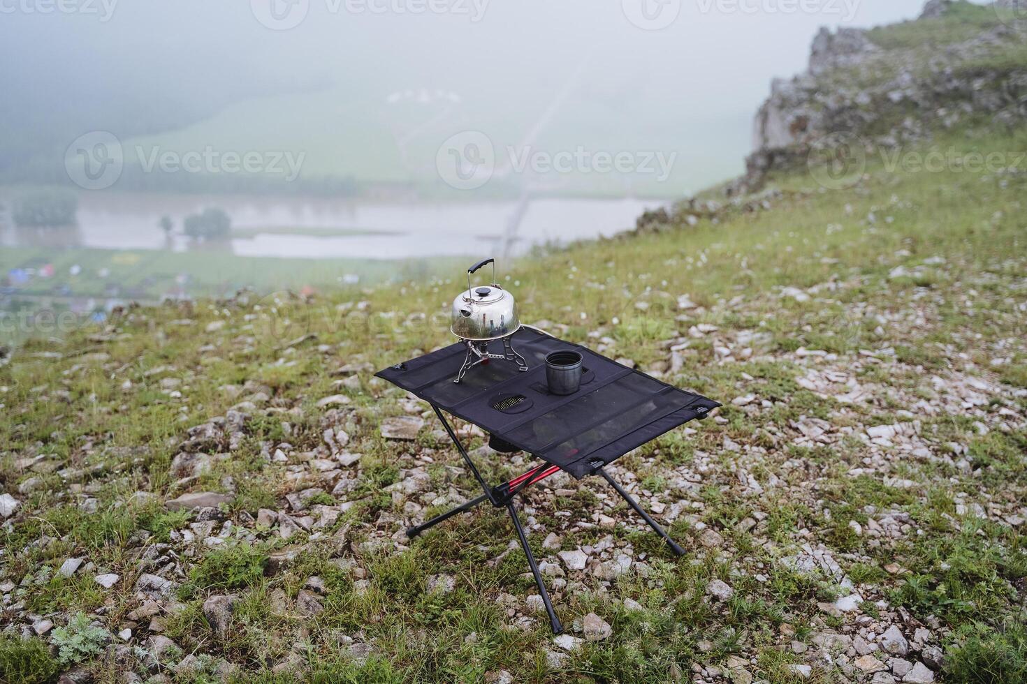 picnic nel natura, un' metallo bollitore sta su il tavolo nel un' escursione, turista piatti per campeggio. foto