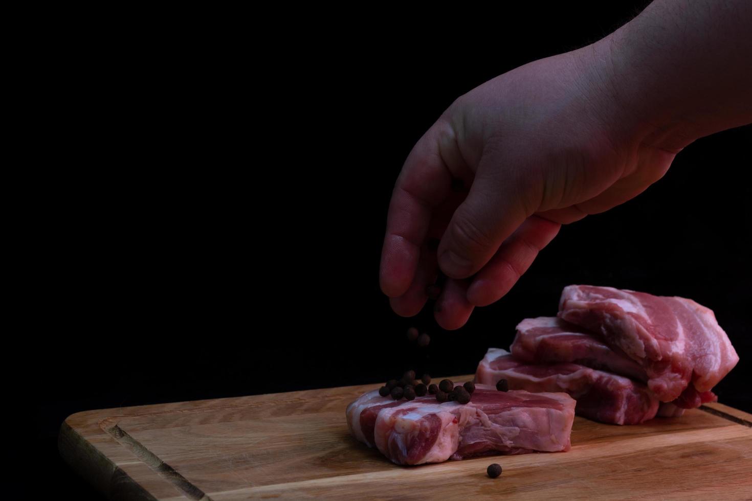 pezzo di petto di maiale su una tavola da cucina su uno sfondo scuro. foto