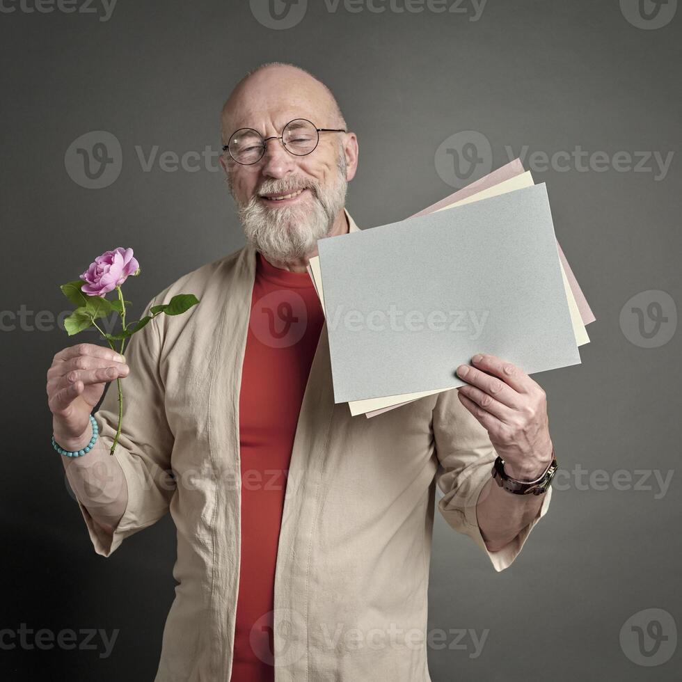 anziano uomo con rosa rosa e vuoto carta foto