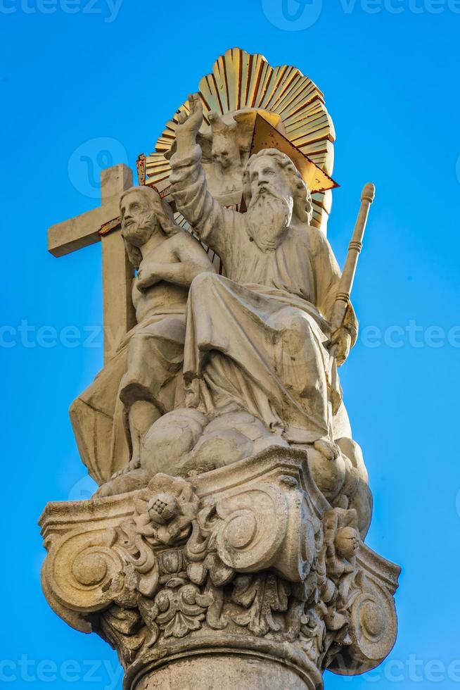 Colonna con la statua di Abramo e Isacco davanti alla chiesa cattolica romana di San Carlo Borromeo a Pancevo, Serbia foto