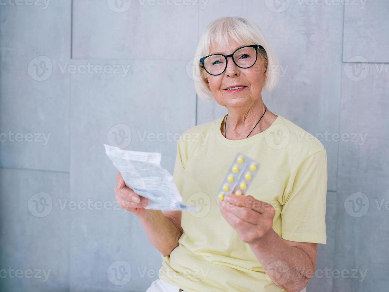 donna anziana con gli occhiali che legge le istruzioni di medicina. età, assistenza sanitaria, concetto di trattamento foto