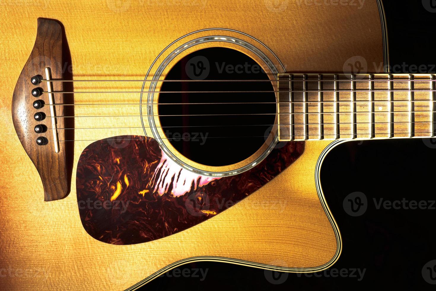 dettaglio della chitarra acustica folk su sfondo nero foto