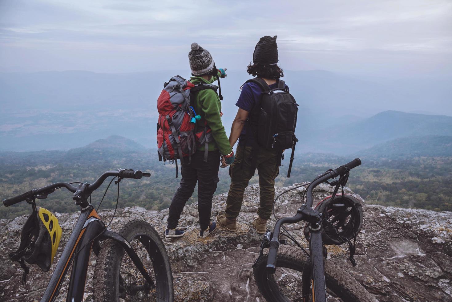 donne e uomini amante asiatici viaggiano nella natura. viaggio relax andare in bicicletta natura selvaggia. in piedi su una scogliera rocciosa. Tailandia foto