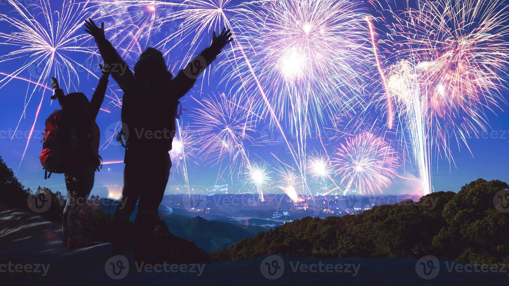 amante donne e uomini asiatici. alzati e alza le mani per guardare i fuochi d'artificio. felice il giorno della celebrazione del nuovo anno in montagna in thailandia. foto