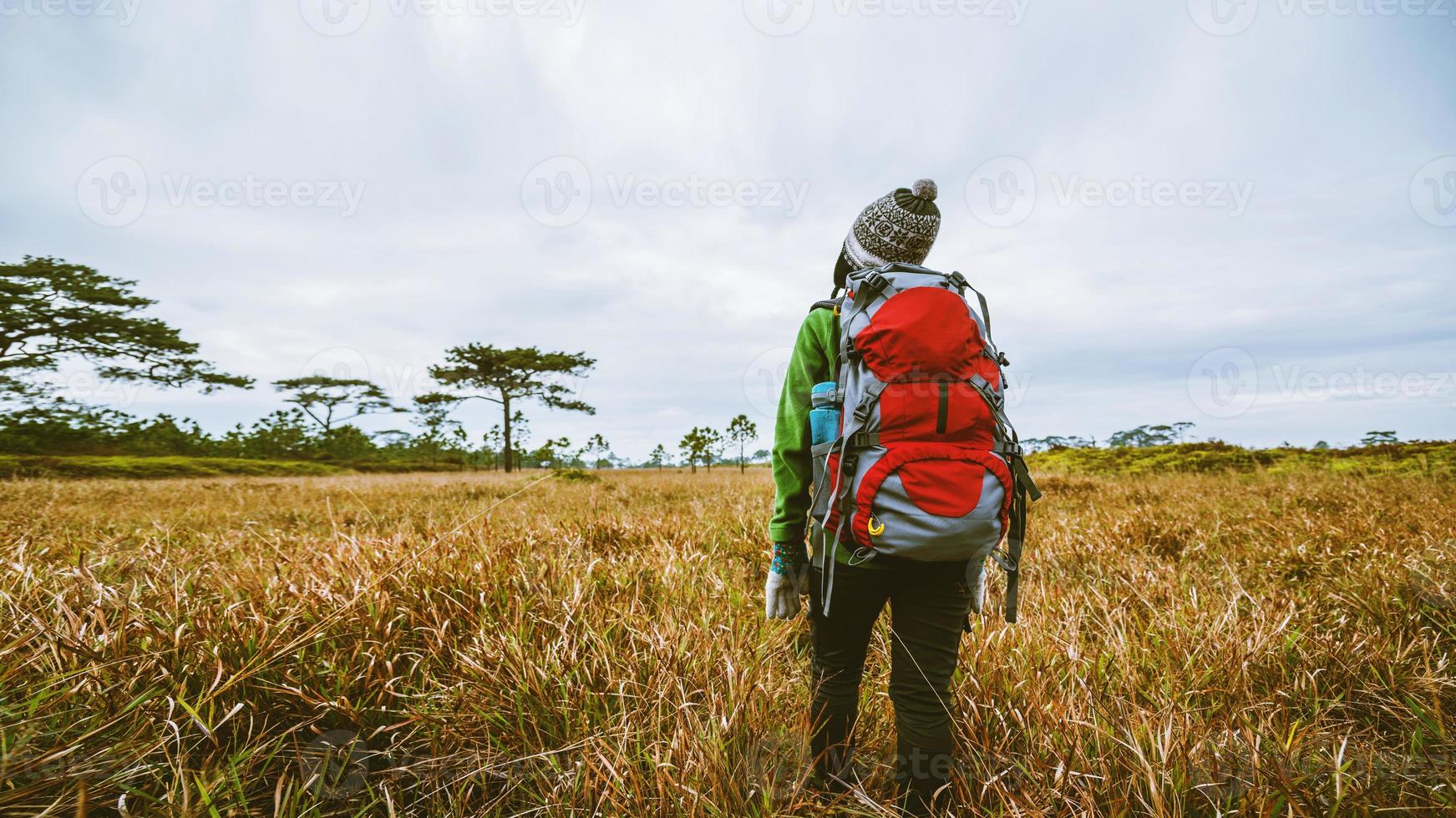 natura di viaggio donna asiatica. viaggiare rilassati. in piedi erba naturale tocco sulla montagna. ragazza con uno zaino che cammina nella foresta di erba. natura di viaggio. viaggiare rilassati. foto