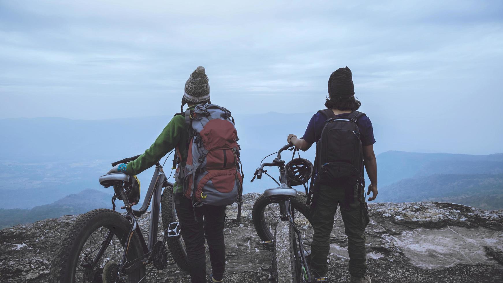 donne e uomini amante asiatici viaggiano nella natura. viaggio relax andare in bicicletta natura selvaggia. in piedi su una scogliera rocciosa. Tailandia foto