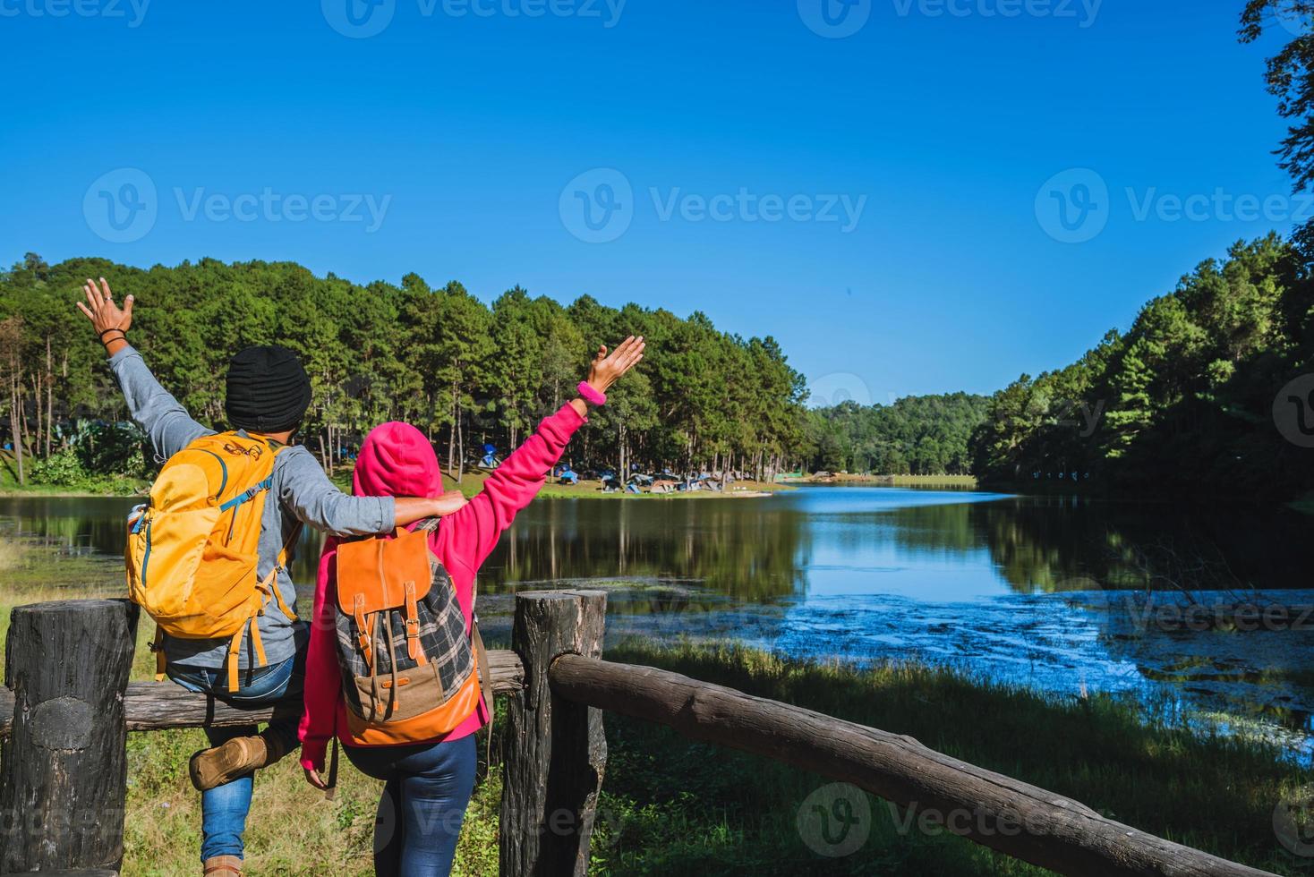 coppia di viaggiatori con zaino in piedi in cima alla natura del punto di vista, godersi l'alba sulla superficie nebbiosa del lago, giovani uomini e amiche asiatiche viaggiano nella natura sul parco di montagna pang ung foto