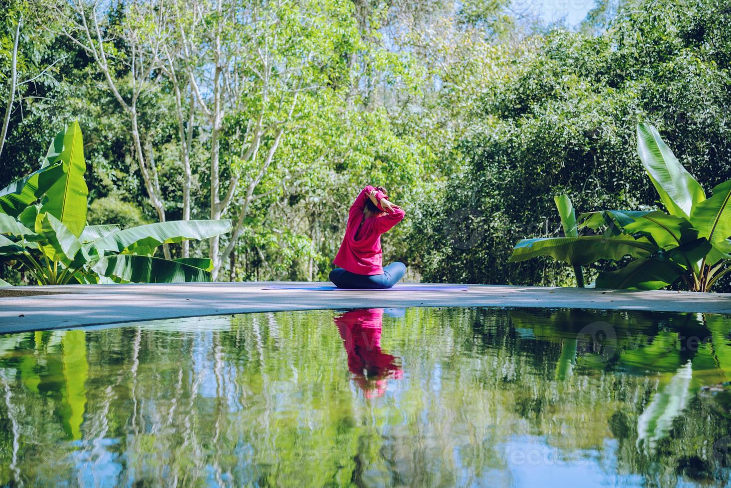 giovane ragazza in piedi corpo rilassante, esercizio di yoga. sorgenti termali nel parco nazionale, viaggi nella natura termale, relax ed esercizio fisico in piscina. foto