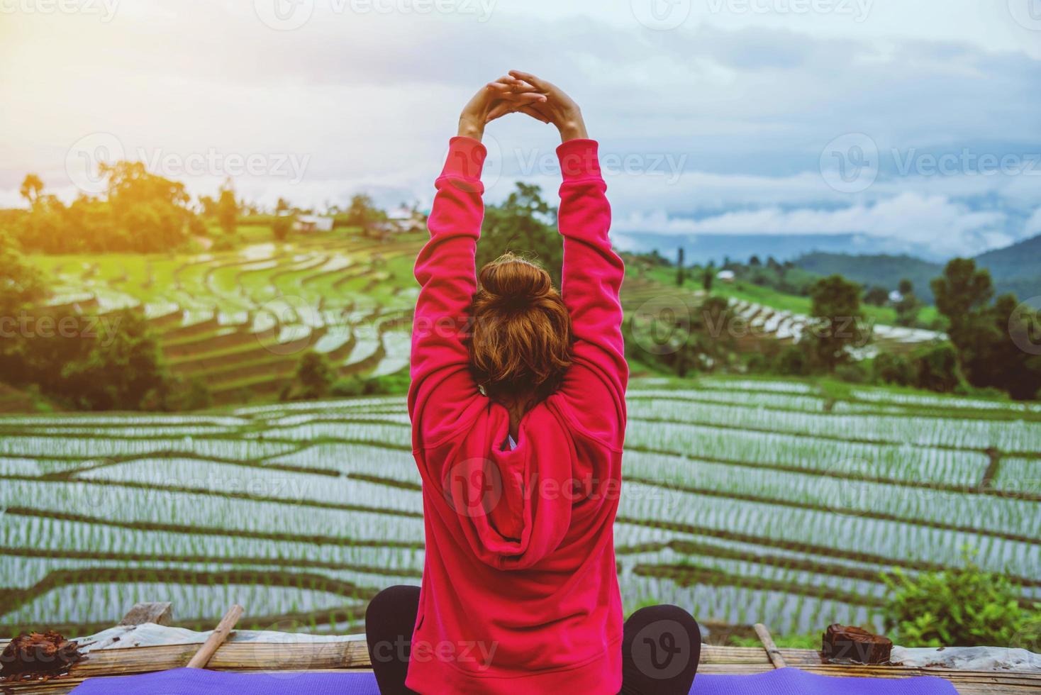 donna asiatica rilassarsi in vacanza. gioca se lo yoga. sul balcone paesaggio campo naturale.papongpieng in thailandia foto