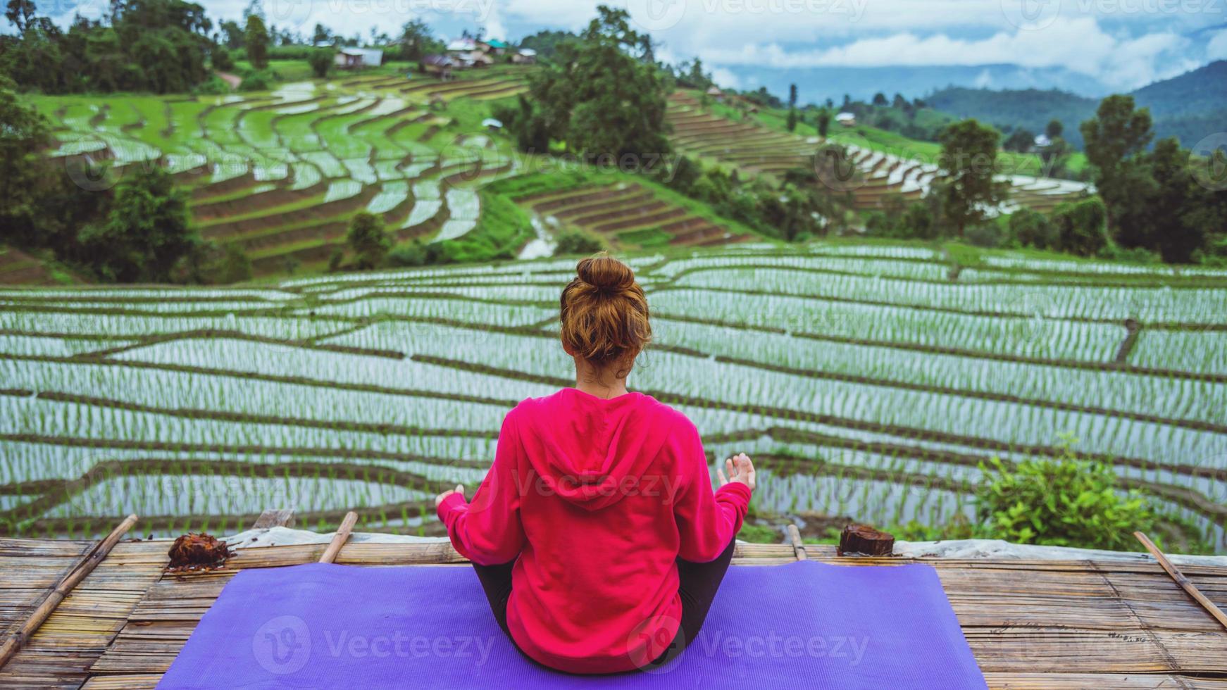 donna asiatica rilassarsi in vacanza. gioca se lo yoga. sul campo naturale del paesaggio del balcone. papongpieng in thailandia. foto