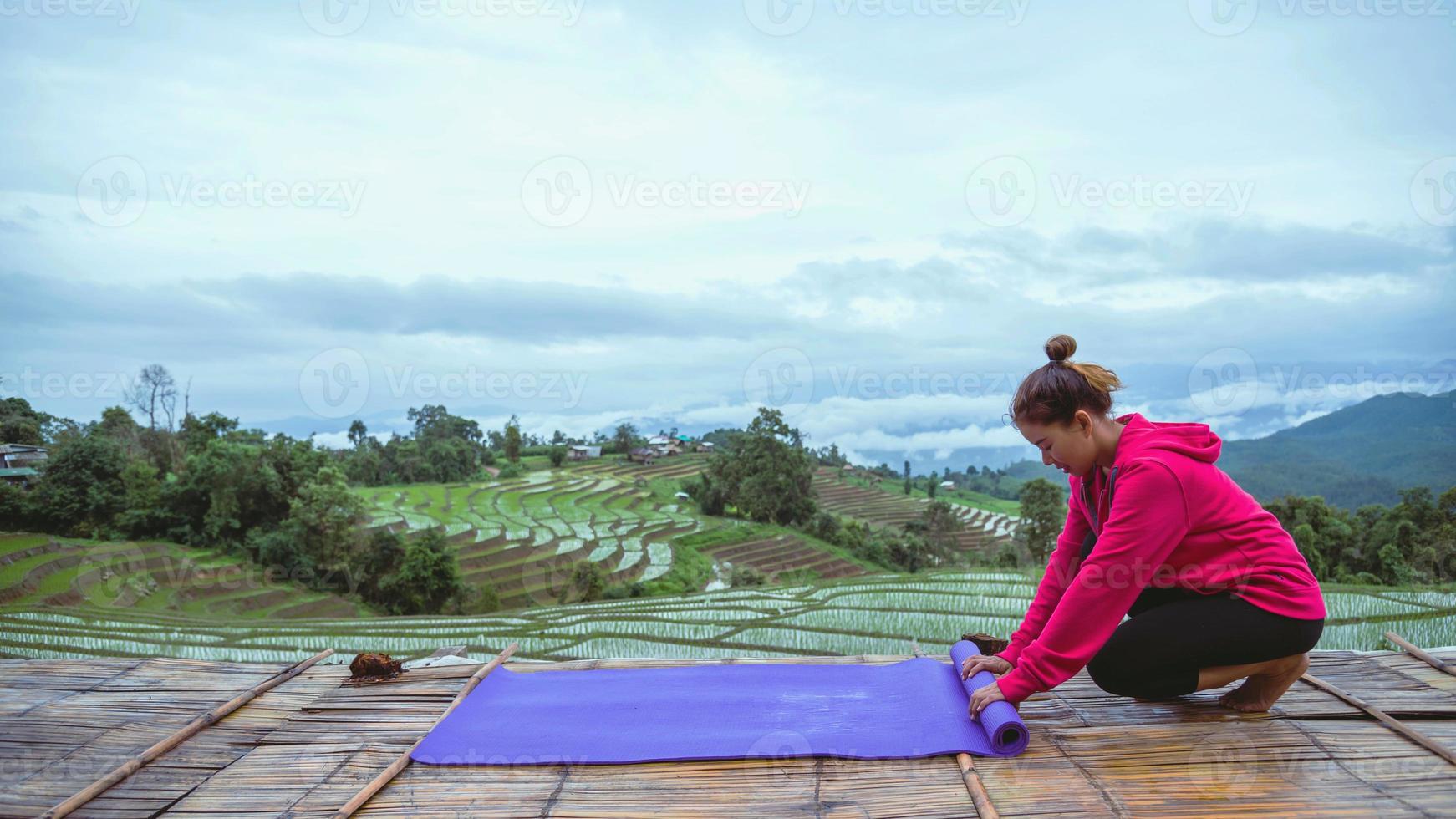 donna asiatica rilassarsi in vacanza. gioca se lo yoga. sul balcone paesaggio campo naturale.papongpieng in thailandia foto