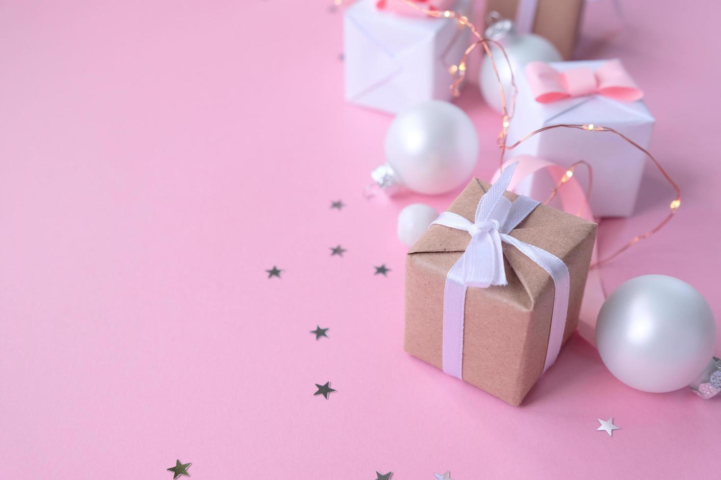 sfondo di natale con decorazioni e scatole regalo su sfondo rosa foto