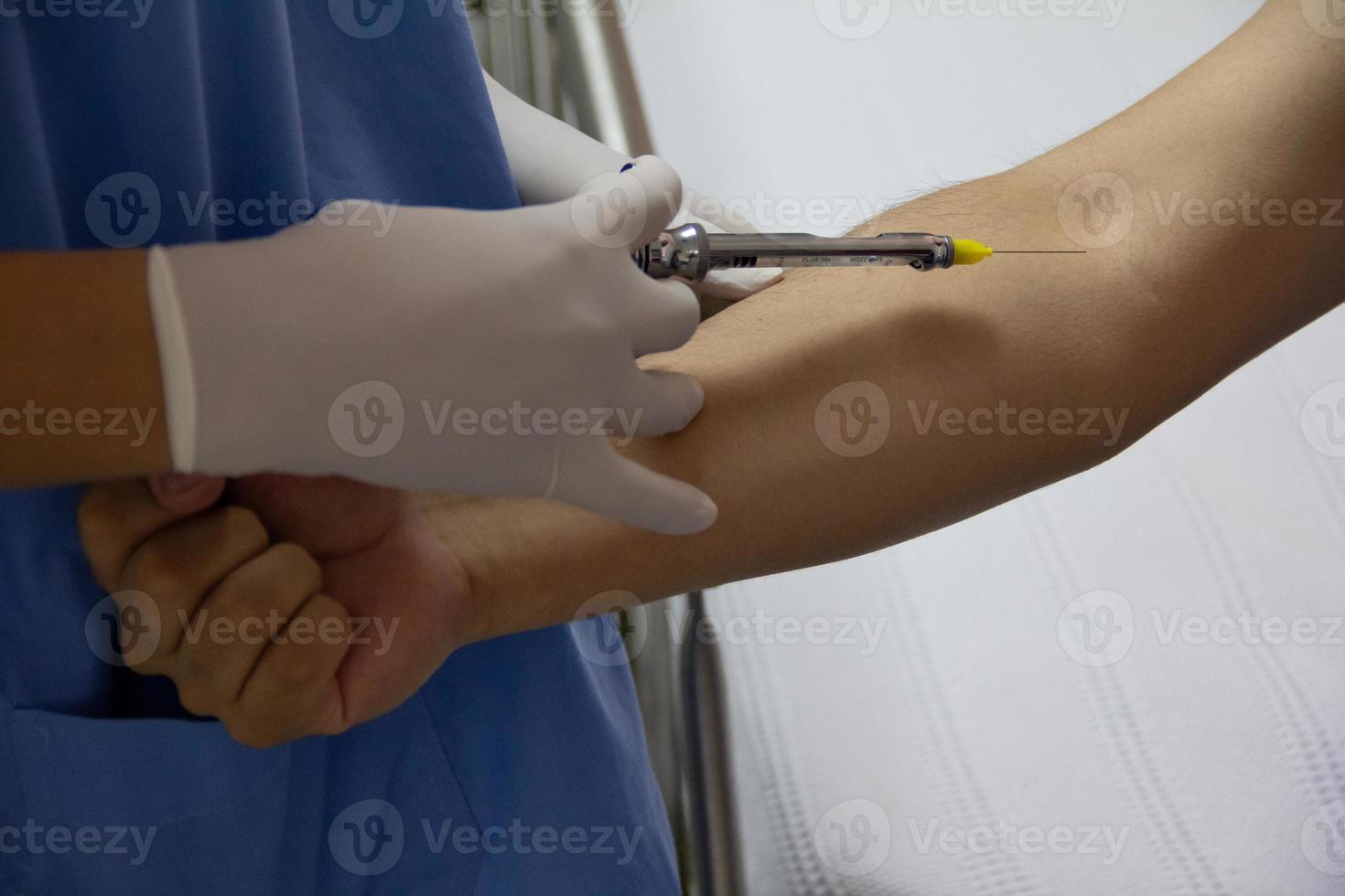 primo piano delle mani di un medico che fanno un'iniezione. foto