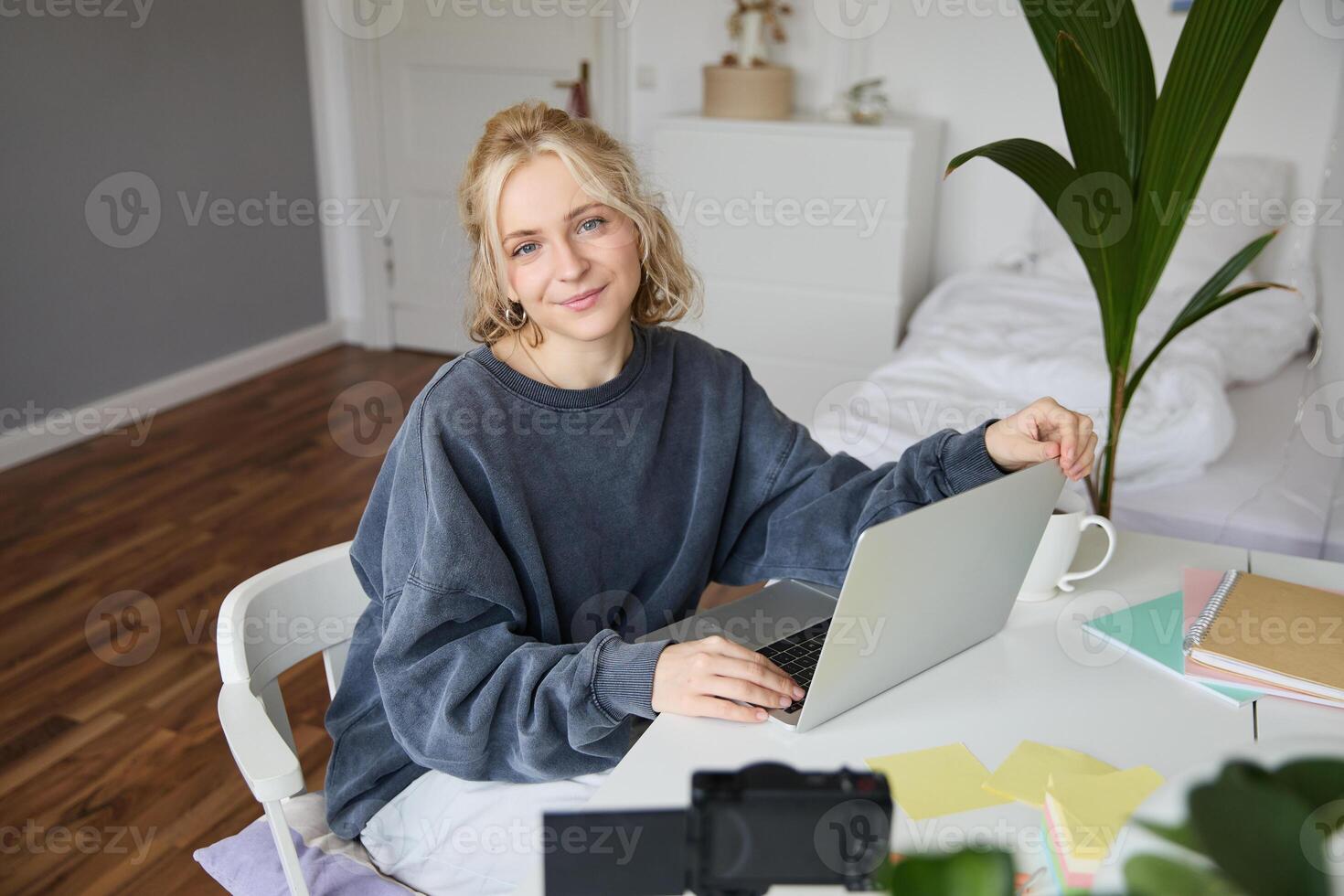 ritratto di giovane donna, stile di vita blogger, registrazione video blog di sua vita e quotidiano routine, seduta nel davanti di computer portatile, parlando per seguaci, seduta nel sua camera foto